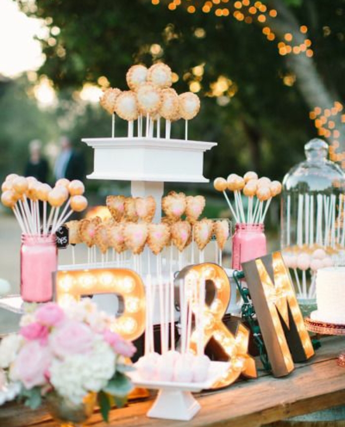 candy bar en rose, blanc et or, sucettes de gateau, table rustique choc, bouquet de fleurs, lettres lumineuses, mariage en plein air