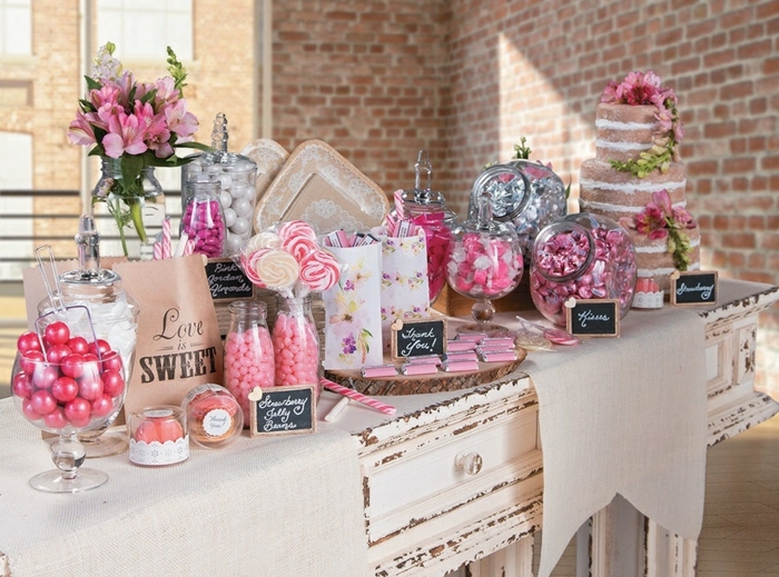 candy bar mariage vintage en rose et blanc, sucettes, caramels, petits chocolats, dragées, fleurs rose, table vintage, gateau a etages gourmand