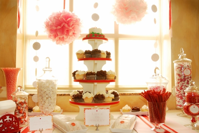 dragées, boules de gomme. cupcakes, bonbons lindor, decoration bar a bonbon en rouge, blanc et rose, fleurs en papier de soie rose