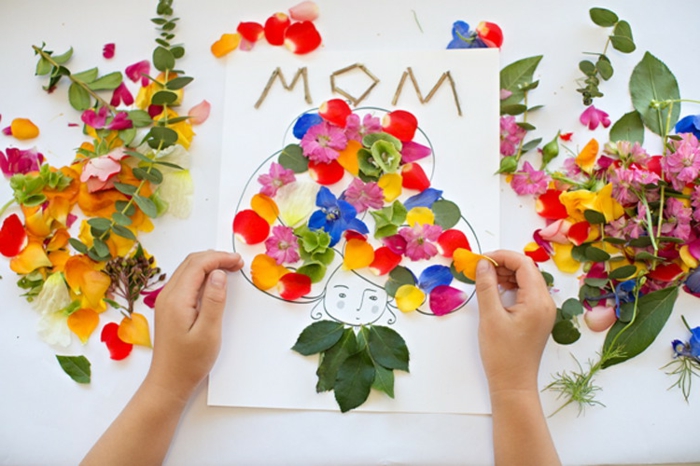 carte de voeux pour la fete des mères dessin et matériaux naturelles, des pétales de fleurs multicolores, visage femme maman, cadeau fete des meres