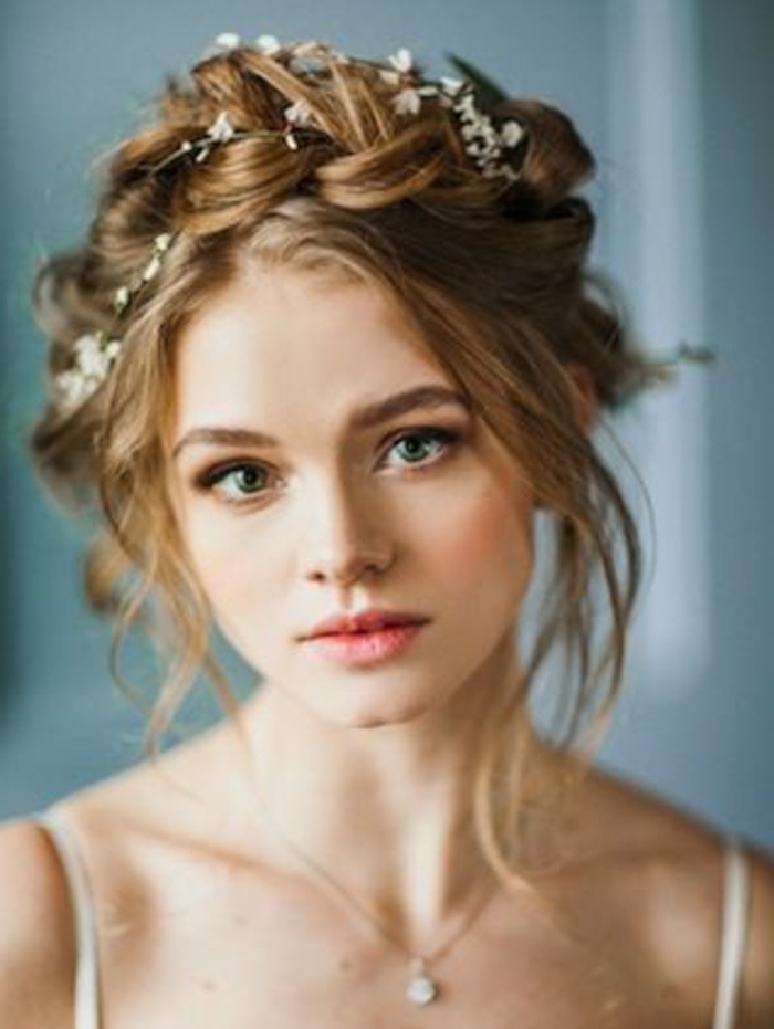 idée de coiffure mariage élégante, couronne de tresse avec petites fleurs blanches accessoire, mèches rebelles autour du visage