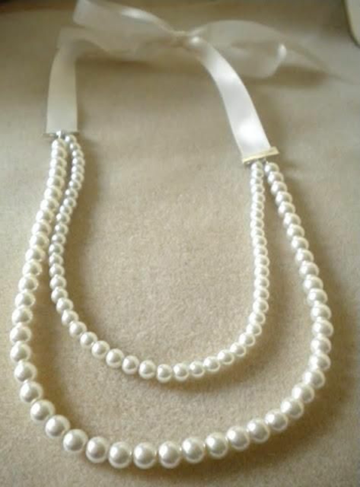 collier de perle blanche avec partie en satin et gros noeud 