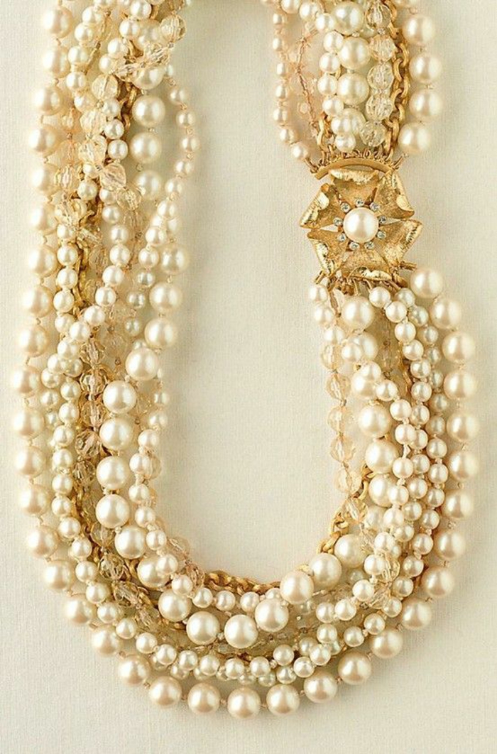collier de perle de culture avec grand sautoir en forme de fleur dorée qui a dans son centre une grande perle