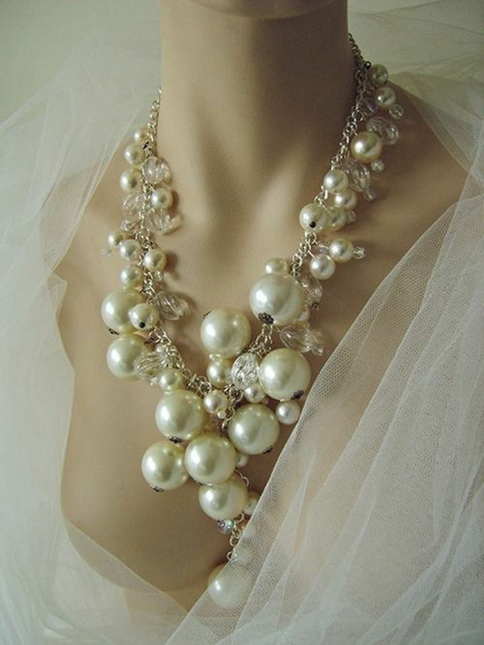 collier de perle sur une chaine en métal blanc avec un voile blanc pour le jour J