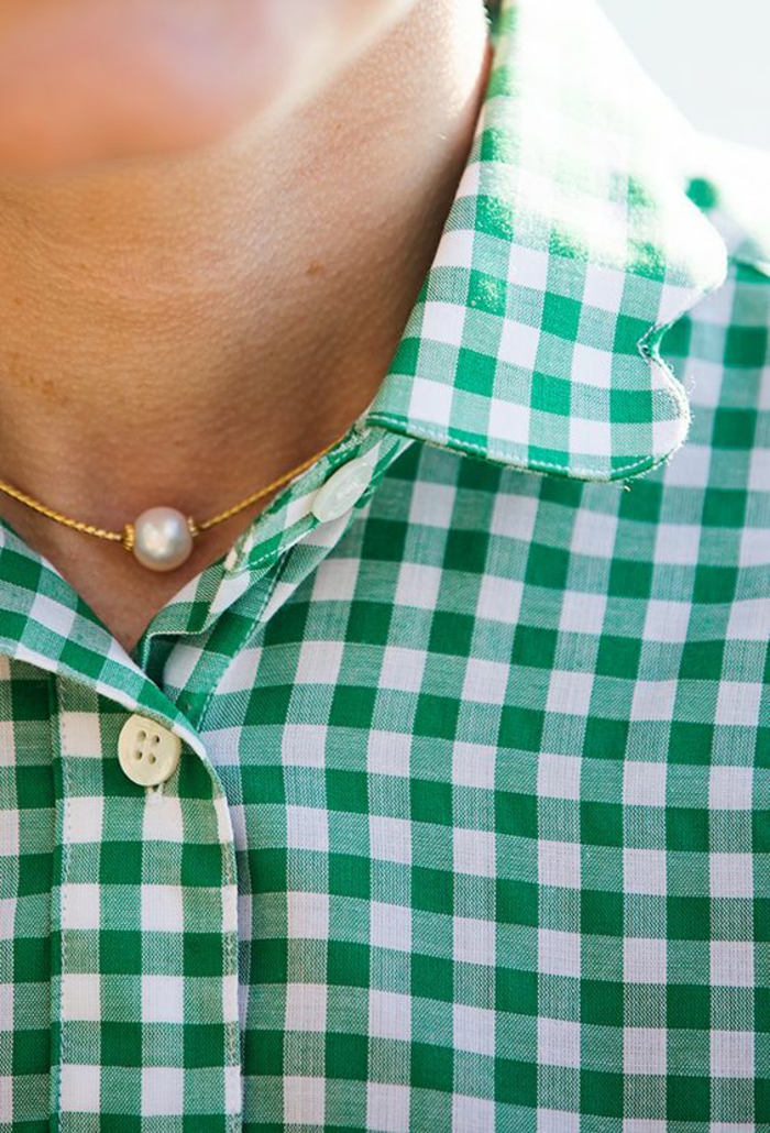 le collier de perle en or délicat et féminin meme sur chemisier à carreaux verts et blancs 