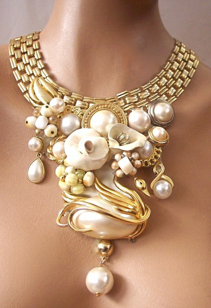 collier en perle en métal doré avec des motifs nature cygne et fleurs blanches 