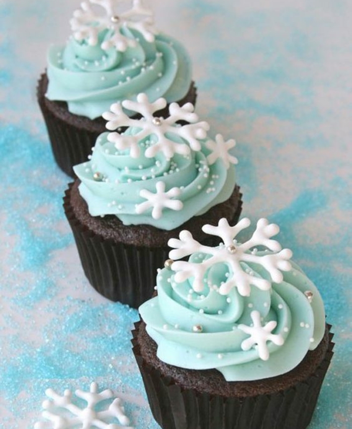 cupcakes chocolat, glacage crème bleue, flacons de neige et perles en sucre comestibles, cupcahe de Noel