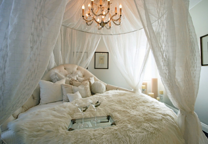 chambre boudoir, voiles blanches, tête de lit capitonné, cadres photos noires, murs blancs, bougies