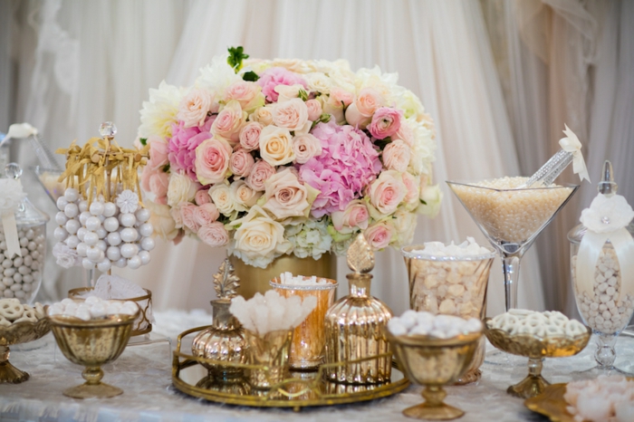 candy bar mariage, dragées blancs, centre de table floral, bouquet de fleurs, fond de rideaux blanc, nappe blanche, contenants en verre et contenants dorés