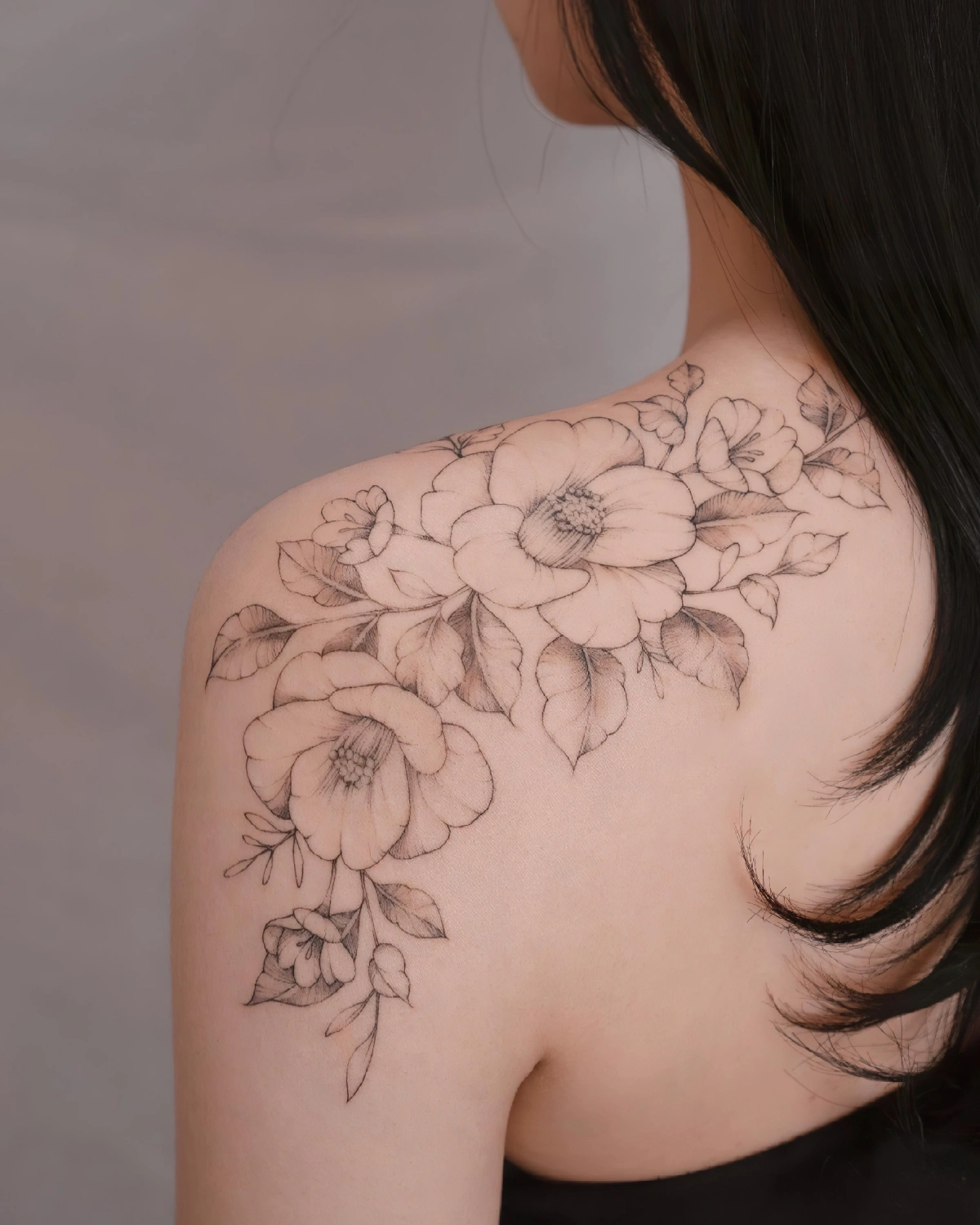 dessin fleurs feuilles petales tatouage epaule femme cheveux longs