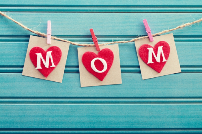 des coeurs en feutrine rouge avec des lettres maman, suspendus par des pinces à linge, cadeau pour la fête des mères