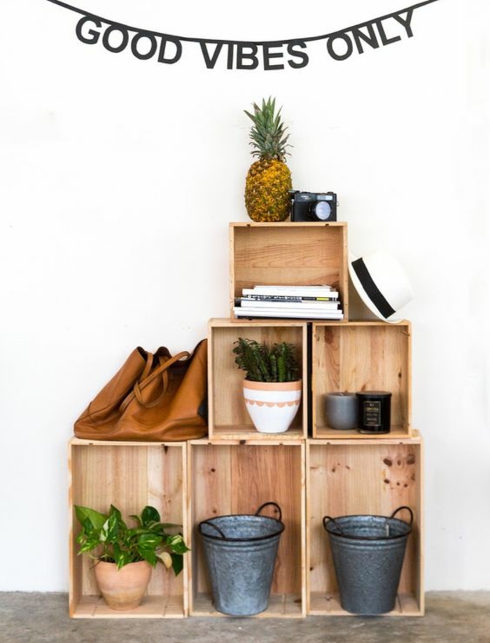 cagette en bois projet deco, plusieurs caisses rangées de maniere asymétrique, seaux vintage, pots de fleurs, plantes vertes, livres, sac à main