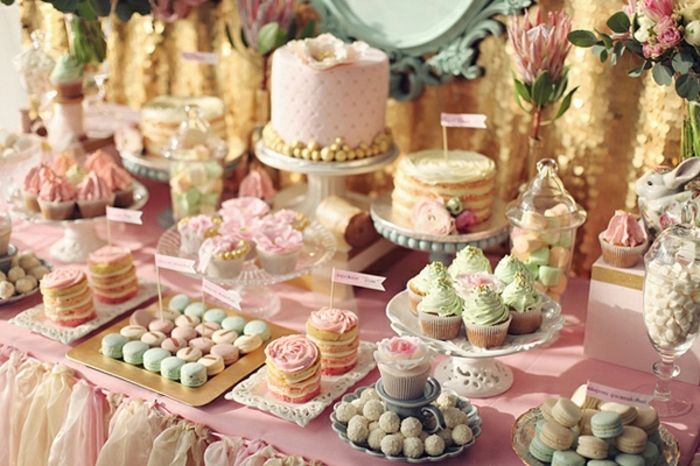 decoration bar a bonbon, cupcakes, macarons, bonbons, pistilles, idee deco mariage, pompons a franges, fleurs, fond de décor doré, nappe rose