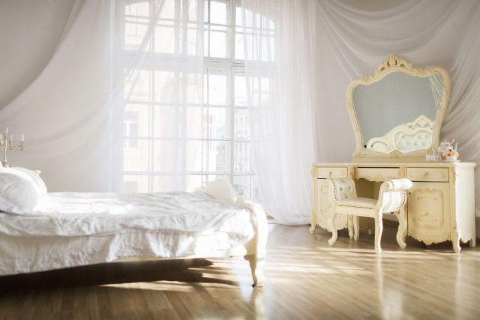 idée déco chambre, grande fenêtre à carreaux, voiles blanches, bougeoirs dorés, parquet en bois clair