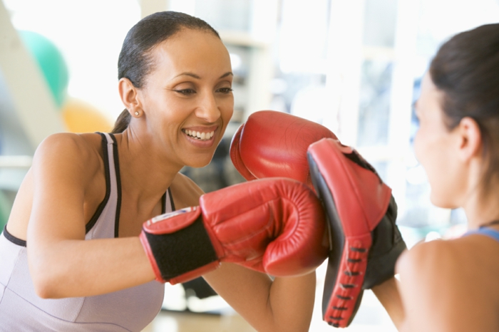 entrainement sportif, boxe femme, gants de boxe rouge, tenue sportive en rose poudré, salle de boxe
