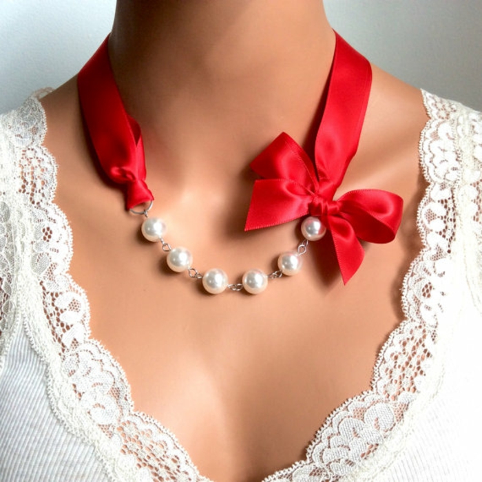 des colliers en perles avec tissu de satin rouge et noeud coquet