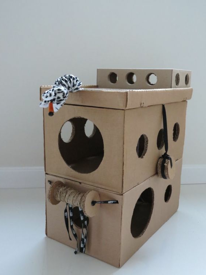 maisonnette chat, construction pour chat en carton avec des jouets de chat accrochés