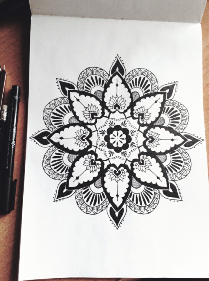 mandala facile a faire, dessin blanc et noir, crayons, agenda, table en bois, mandala à motifs floraux