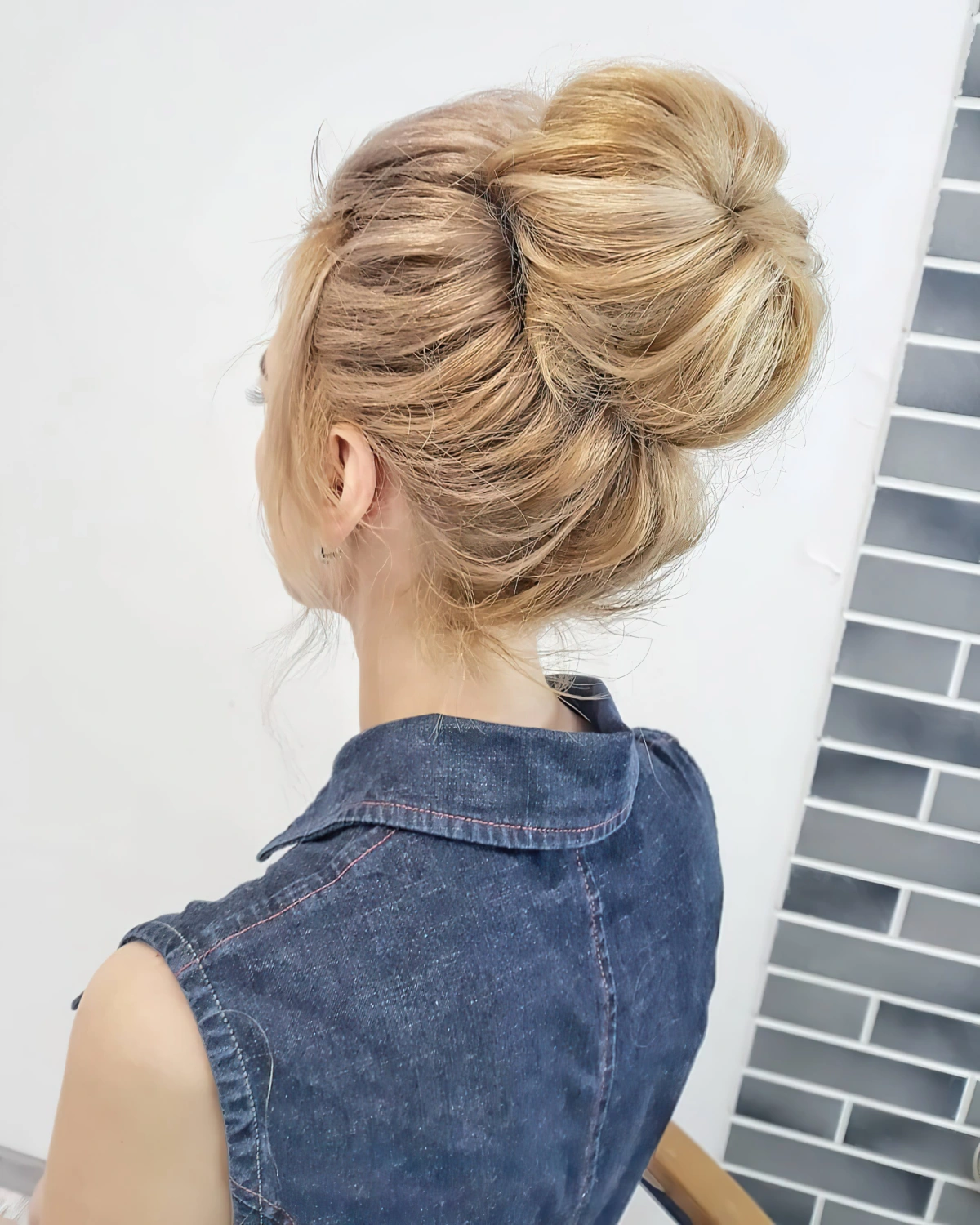 meches tombantes visage chignon haut volume racine veste denim sans manches