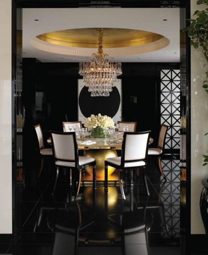 meuble art deco, grande table ronde, chaises blanches, plafonnier glamoureux, sol poli noir
