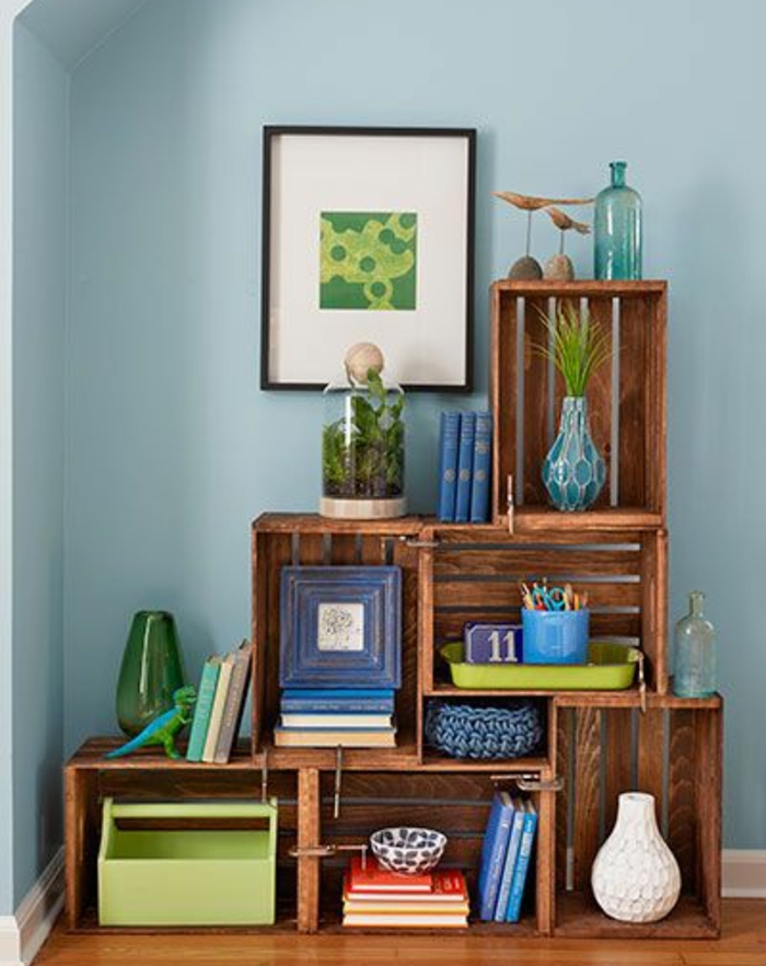 meuble en cagette asymetrique, livres, accessoires décoraifs, plantes, pot a crayon, vases, deco murale, mur couleur bleue