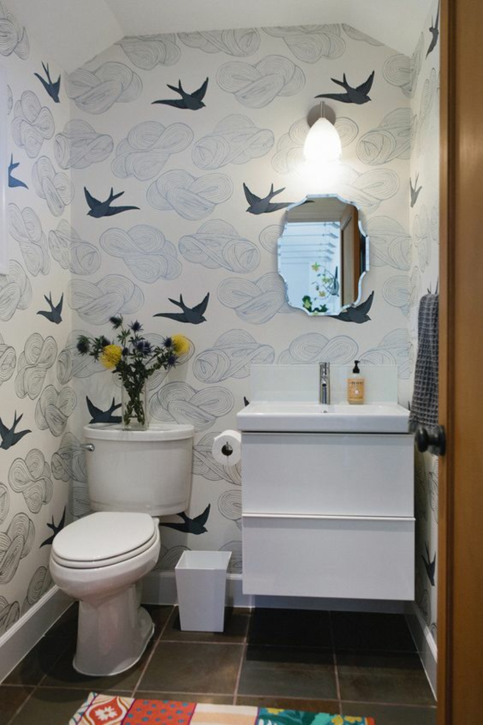 miroir salle de bain eclairant aux bords irréguliers effet trou dans le mur par lequel entrent des hirondelles