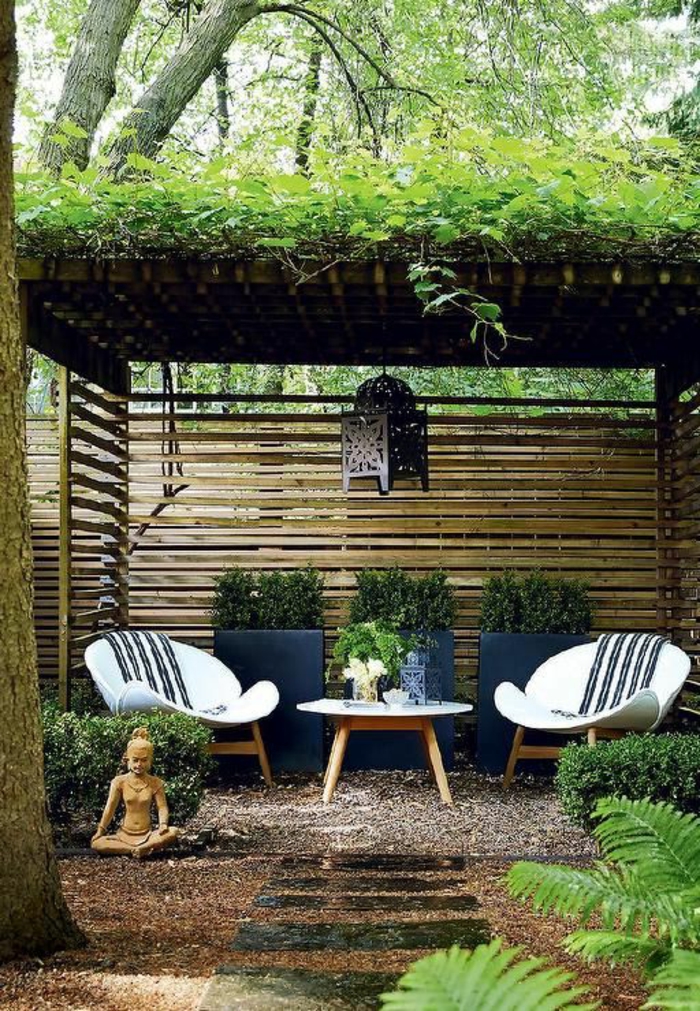 jardin zen, chaises en bois, statue bouddha, clôture en bois, sentier en pierre, terrain avec cailloux