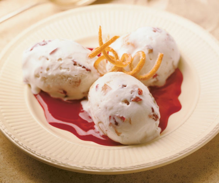 dessert glacé à base de nougat aux fruits confits, nappé de coulis de framboises