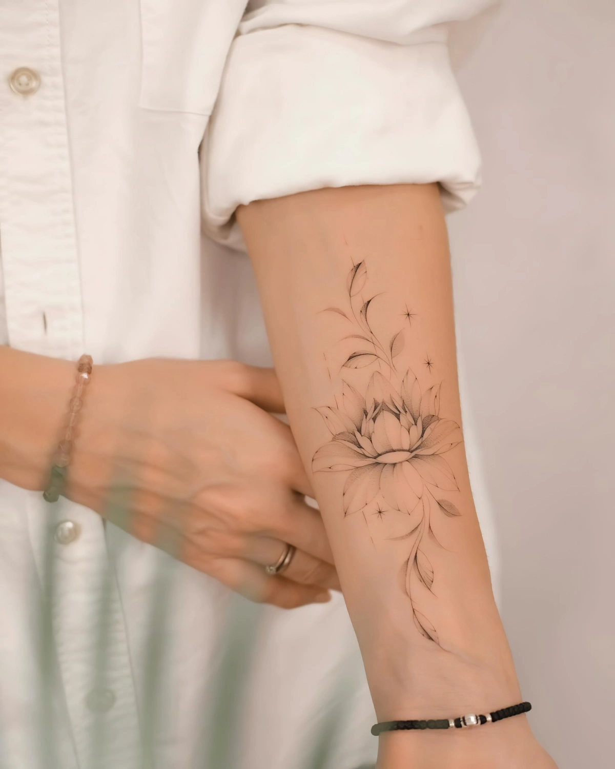 tatouage avant bras femme fleurs petales tiges bracelets chemise blanche