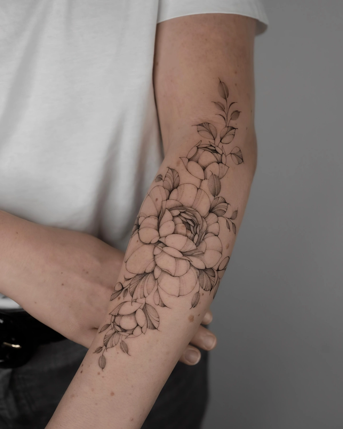 tatouage avant bras femme motifs fleurs tige feuilles pivoine
