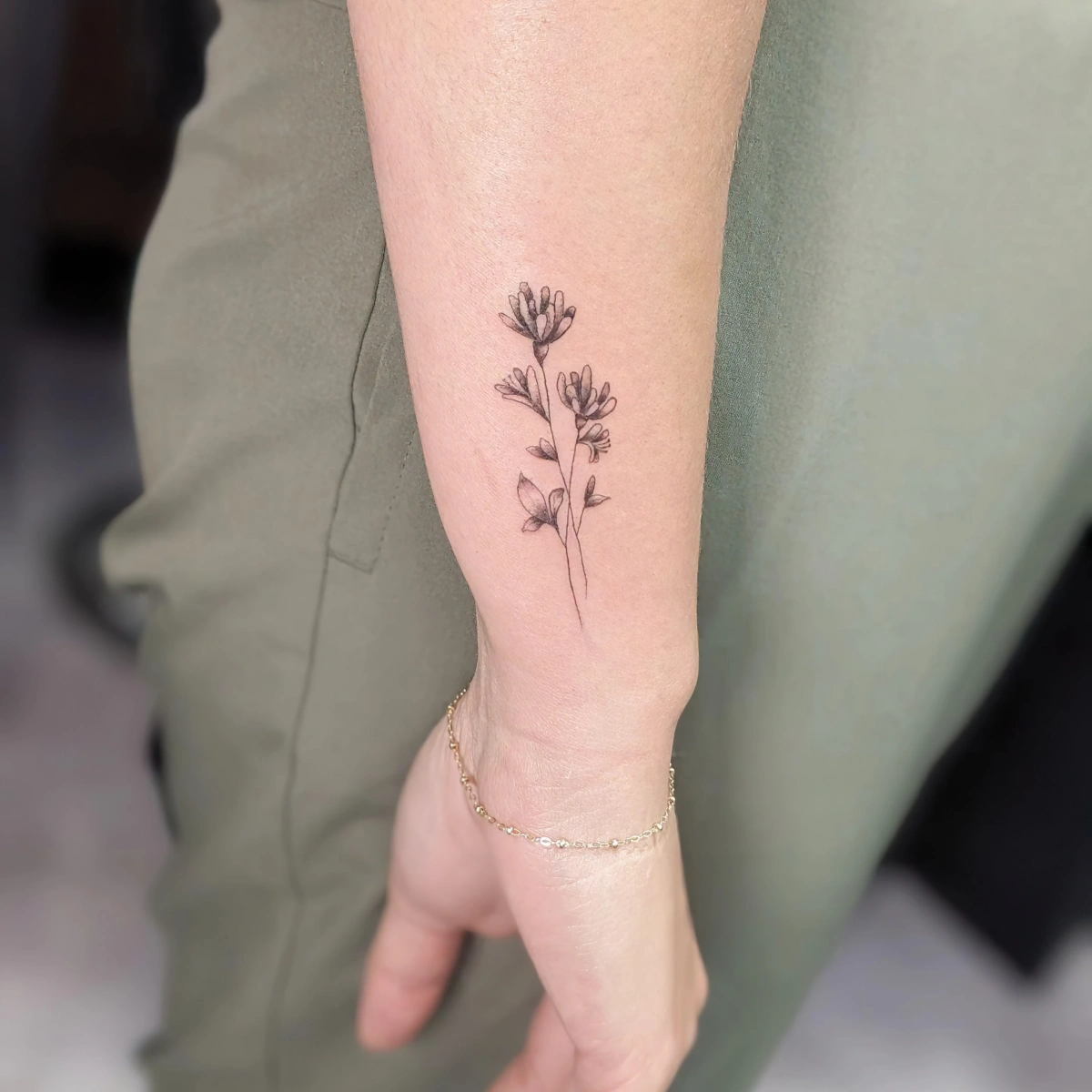 tatouage discret bras femme bracelet dessin fleurs tiges