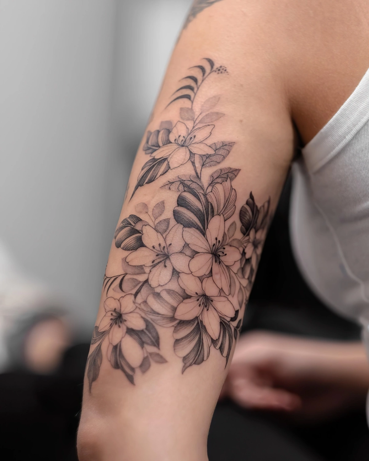 tatouage fleurs petales dessin bras femme debardeur blanc