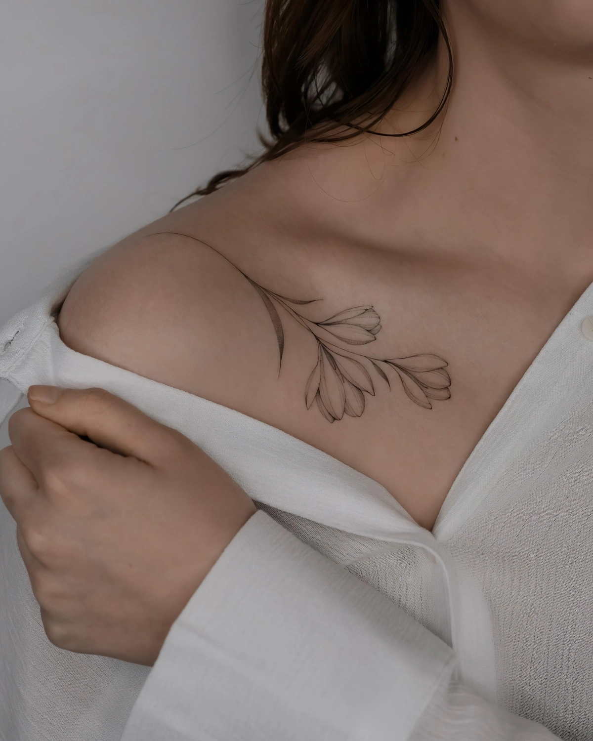 tatouage tiges fleurs crocus chemisier blanc cheveux noirs