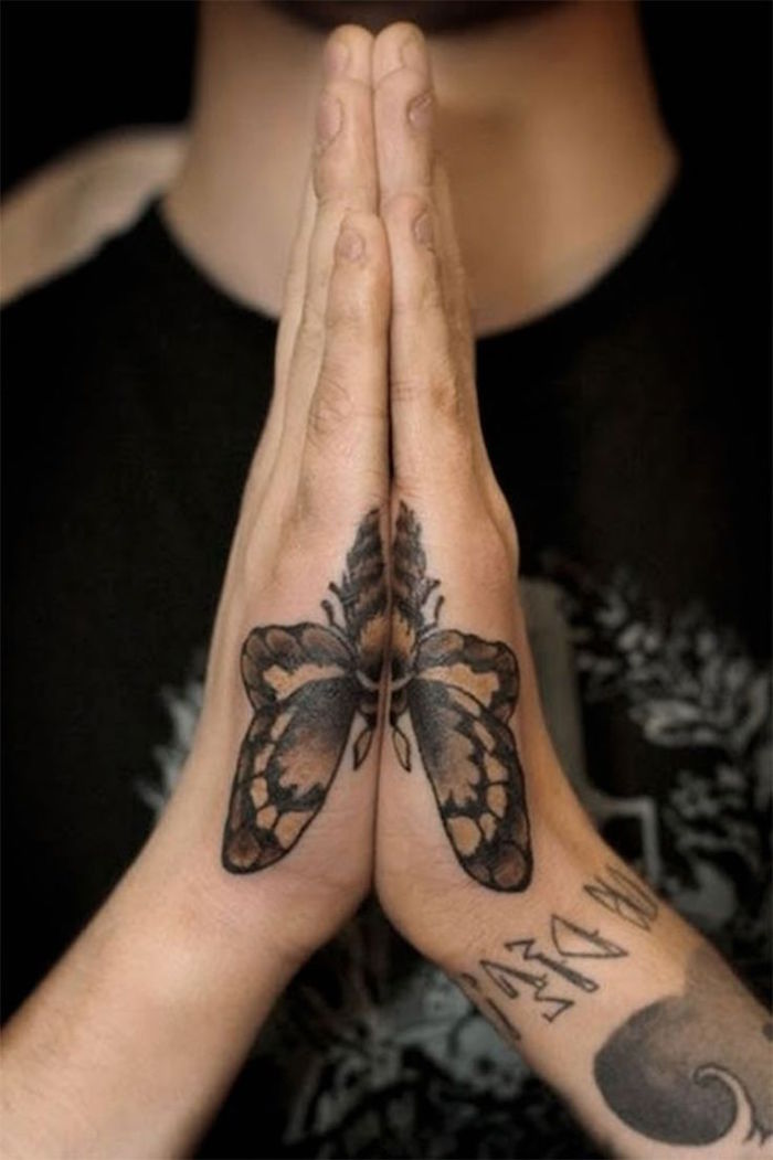 tatouage sur la main homme tranche symétrique papillon