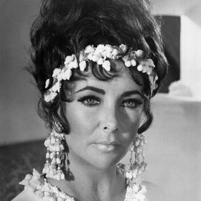 tenue-année-60-femme-Elisabeth-Taylor-avec-une-couronne-de-fleurs-blanche tenue année 60 femme, couronne de fleurs blanches et chignon