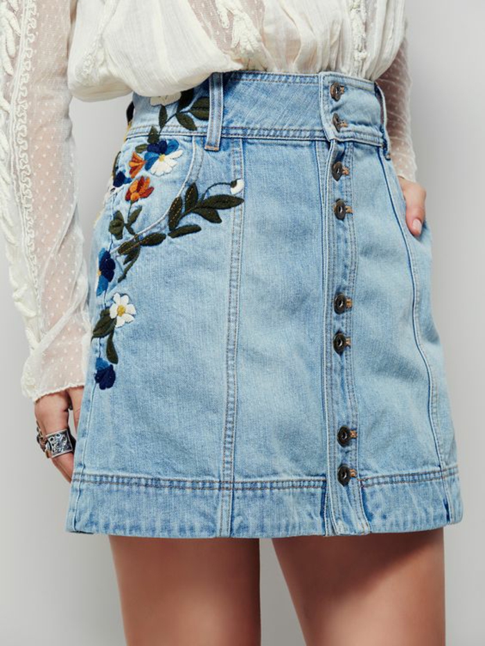 look annee 1980 mini jupe en denim bleu clair avec des broderies de fleurs autour l'une des poches