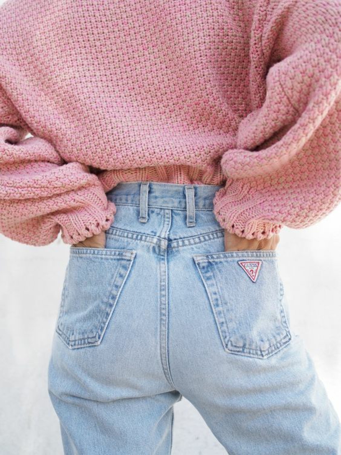 style des années 80 avec pull rose dans un jean en denim clair avec la coupe pantalon typique des 80