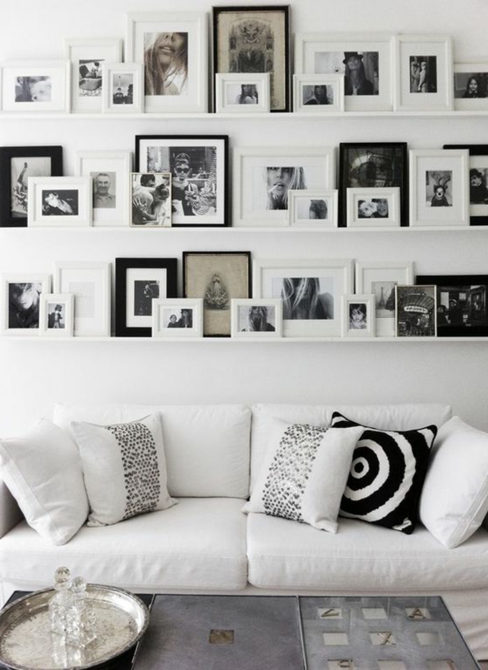 mur de cadres, salon blanc, coussins blancs, cadres photos, photos blancs et noirs