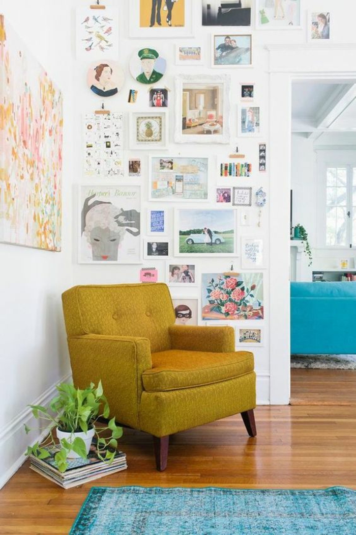 pan de mur en cadres pour un effet galerie d'art à la maison, canapé couleur jaune moutarde et tapis bleu turquoise vintage