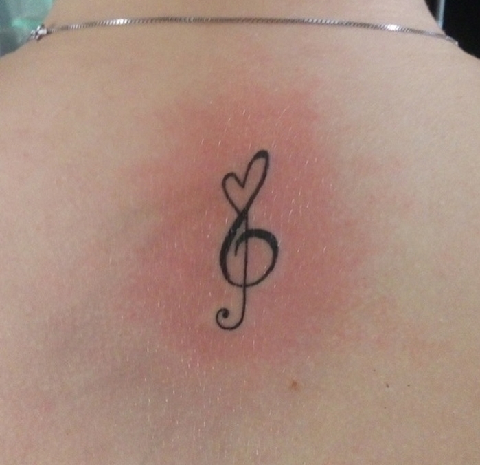 clé de sol tatouage signification dans le dos avec coeur