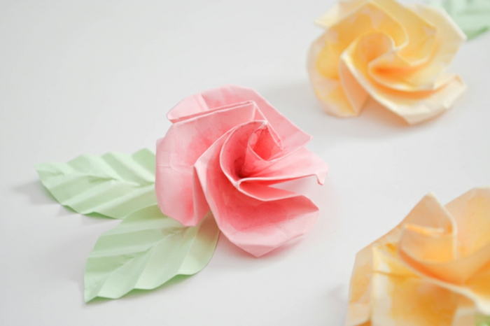 jolie fleur origami, une rose en papier avec feuilles papier pour décorer une guirlande 