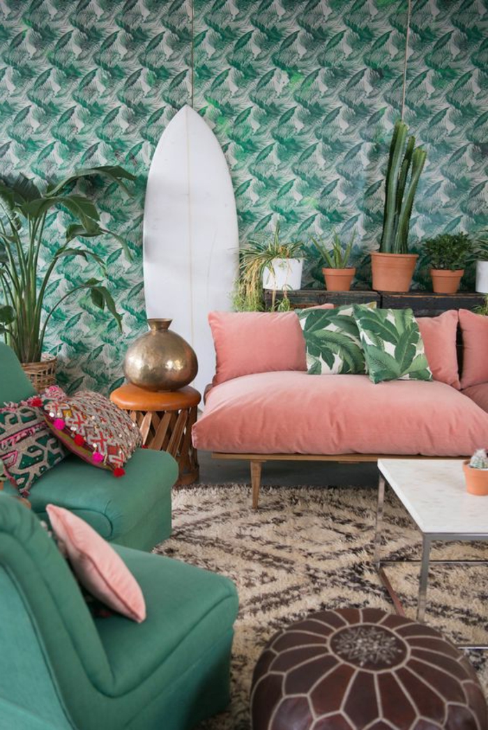 sofa couleur abricot, coussins tropicaux, papier peint végétal, planche de surf décorative