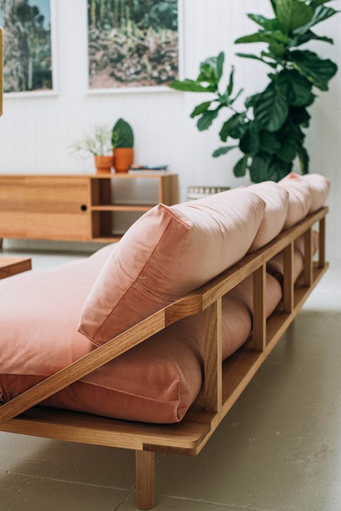 sofa scandinave couleur abricot, commode en bois vintage, peintures, plante verte