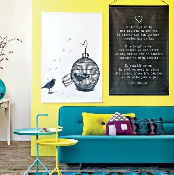idee comment combiner la deco bleu canard avec le jaune, mur d accent et table jaune, canapé et tapis bleus, deco murale affiches en noir et blanc, dessin cagette d oiseau