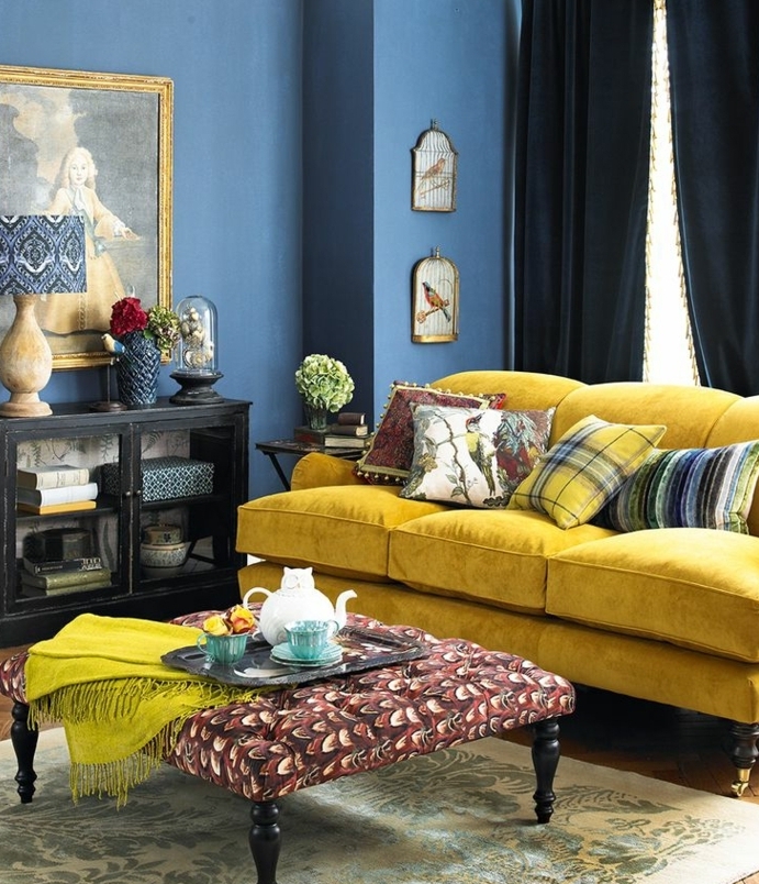 deco bleu et jaune dans in salon vintage, canapé jaune pastel, mur couleur bleue, table basse vintage, peinture murale retro, tapis motifs floraux retro