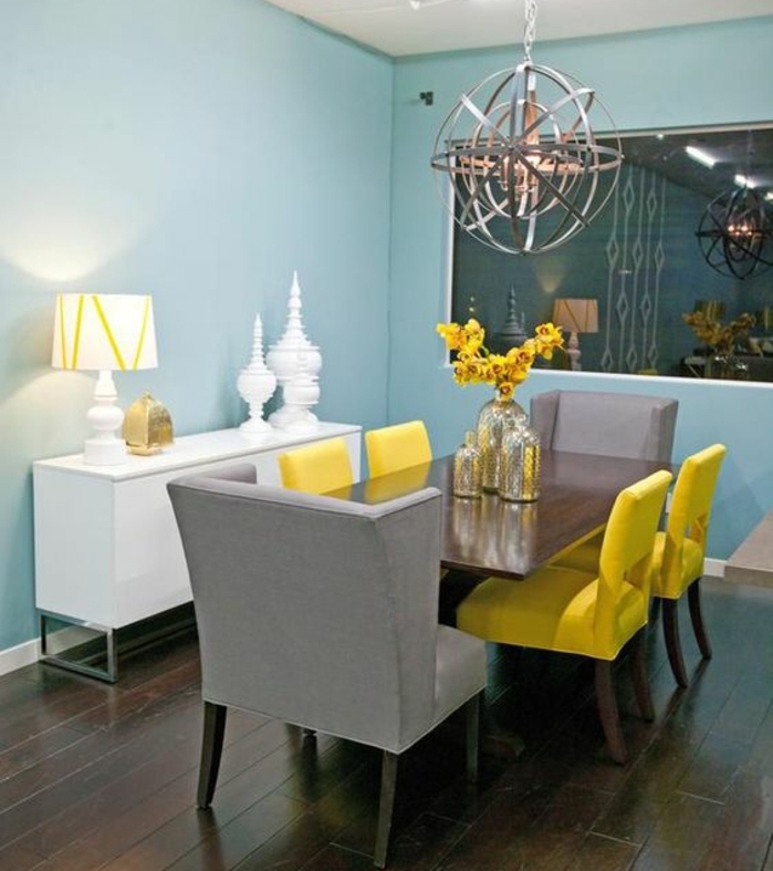 deco bleu et jaune dans une salle à manger, chaises jaunes et gris, mur couleur bleu ciel, vaisselier bas blanc, suspension originale