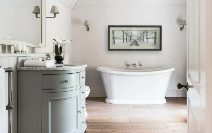 salle de bain campagne chic, meuble salle de bains vert pastel, baignoire à poser blanche, parquet bois, decoration murale en noir et blanc