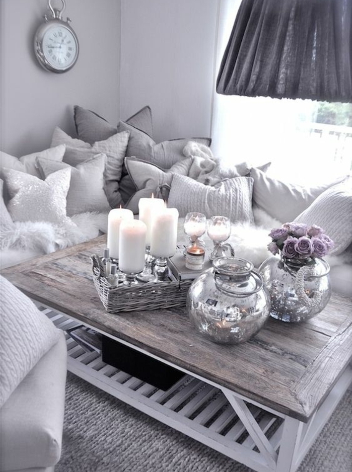 deco campagne chic en gris, table basse en bois brut, bougies, vases de fleurs, coussins blancs et gris, tapis gris, horloge vintage