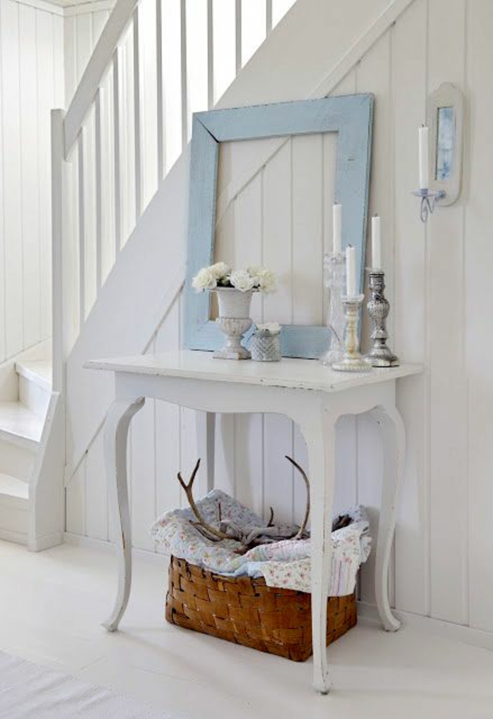 hall d'entrée maison en bleu pastel et en blanc avec un cadre qui sert de décoration sur une table peinte en blanc