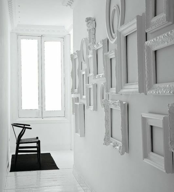 exemple de decoration monochrome, composée de plusieurs cadres photo sur un mur tout en blanc, tapis et chaises noirs, parquet blanc, fenêtre, idée comment décorer un mur blanc